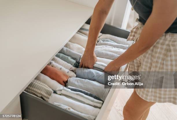 woman folding clothes - clean closet stock pictures, royalty-free photos & images