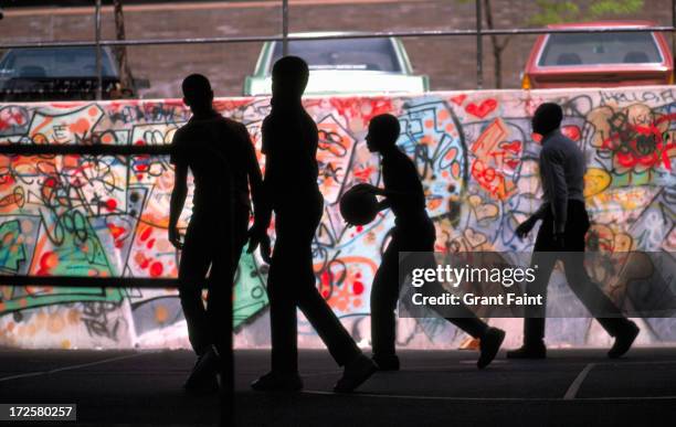 young men playing basketball near wall - new york city wall stock pictures, royalty-free photos & images