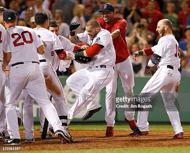Jonny Gomes of the Boston Red Sox is mobbed after he hit a walk-off home run to give the Red Sox a 2-1 win against the San Diego Padres at Fenway...