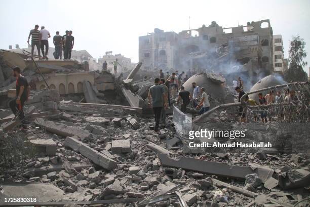 Palestinian citizens inspect the damage to the Al-Sussi Mosque and their homes following Israeli air strikes in the Al-Shati Palestinian refugee camp...