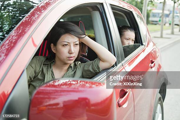 mother and daughter looking frustrated out the window of a car - angry woman red stock pictures, royalty-free photos & images