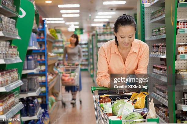 woman reading can in the supermarket, beijing - beijing stock pictures, royalty-free photos & images