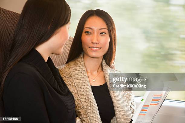 two women talking on a train - magazine retreat day 2 stock pictures, royalty-free photos & images