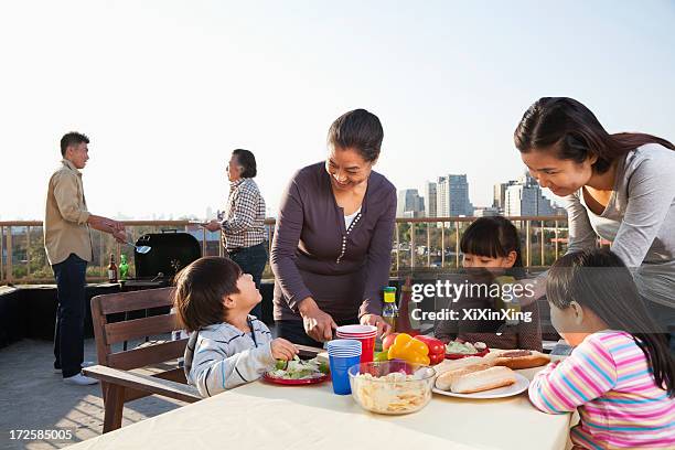 family barbeque party - asian eating hotdog stock pictures, royalty-free photos & images