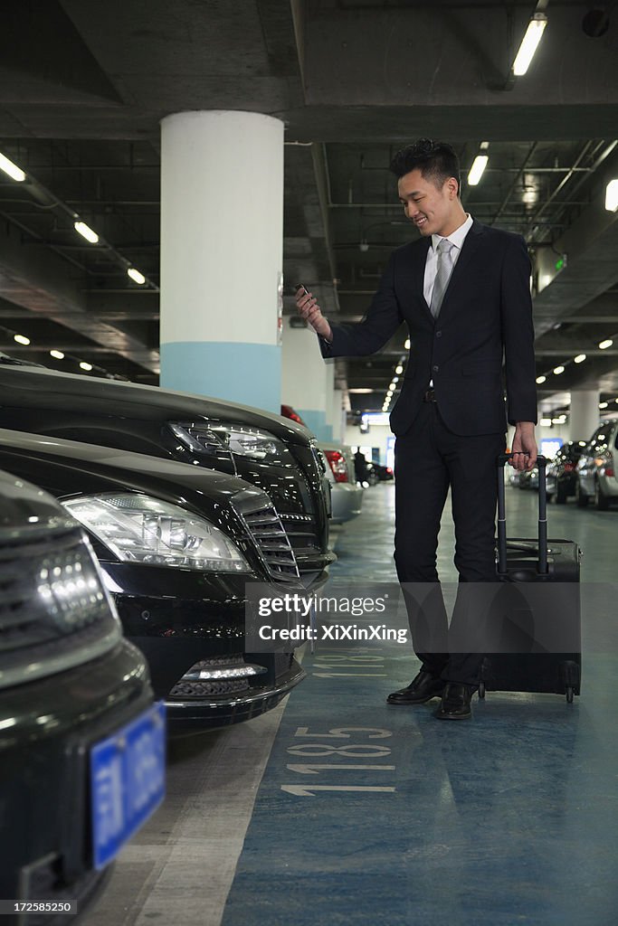 Traveler looking at cell phone in airport parking lot