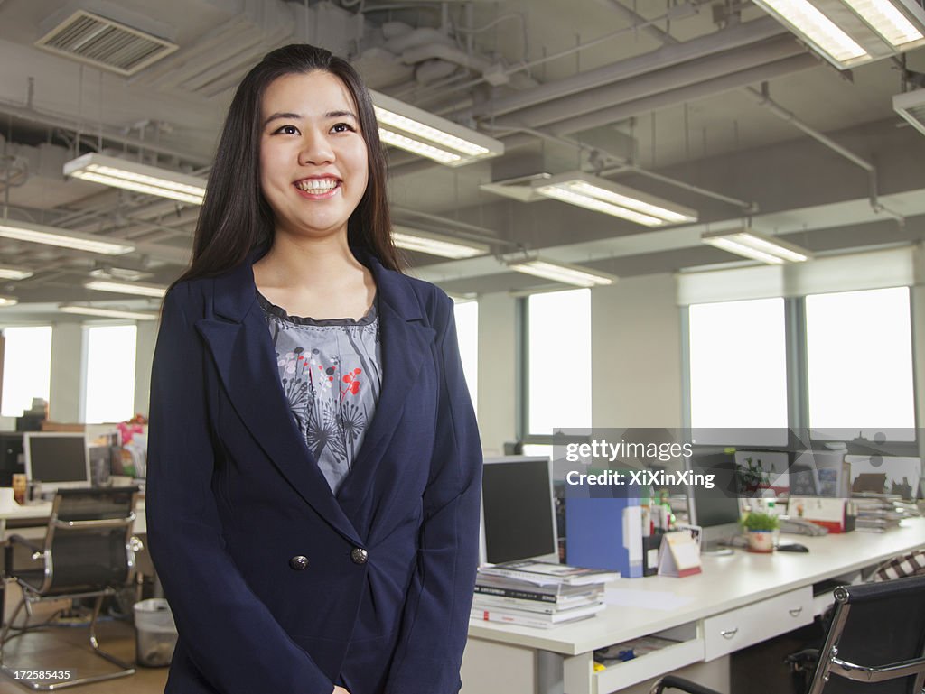 Young businesswoman smiling in the office, portrait