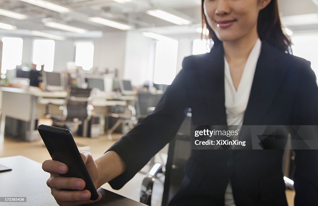 Young Businesswoman using her phone at the office