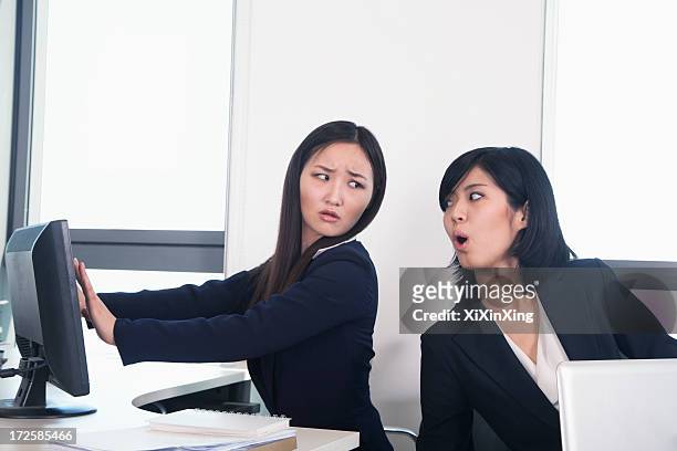 officer worker hiding her computer from coworker - office politics stock pictures, royalty-free photos & images
