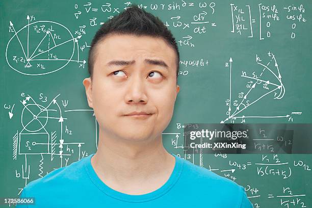 young student in front of blackboard, making a face - algebra stock pictures, royalty-free photos & images