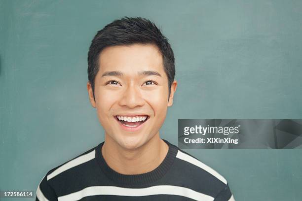 portrait of smiling, happy young man in front of blackboard - man mouth open stock pictures, royalty-free photos & images