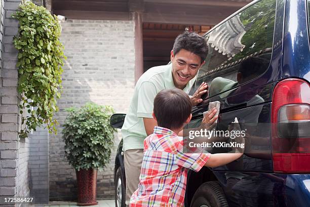 father and son clean their minivan together - rubbing stock pictures, royalty-free photos & images