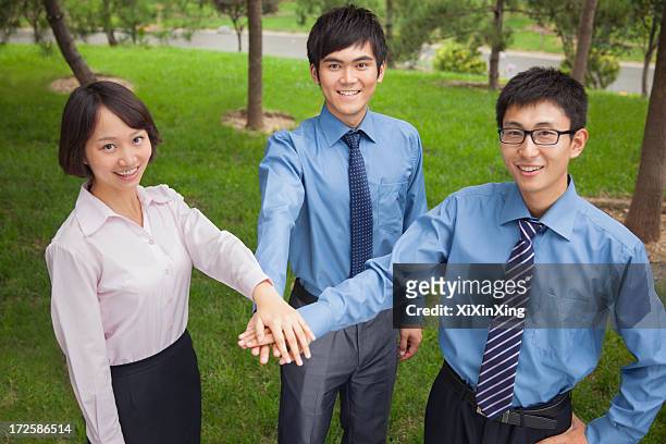 business people putting their hand together as sign of team working - siegerpose stock-fotos und bilder