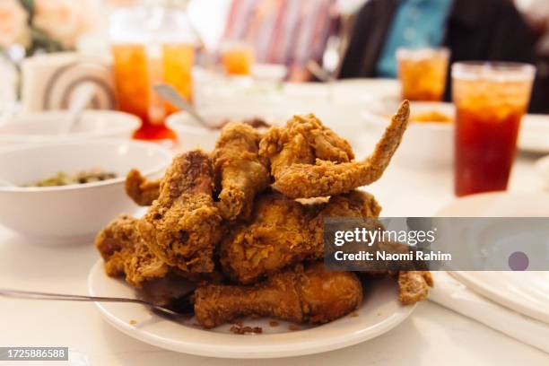 pile of crispy southern fried chicken, on a family dining table - southern usa stock pictures, royalty-free photos & images