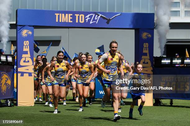 Emma Swanson of the Eagles leads her team on to the field with the junior mascot during the 2023 AFLW Round 07 match between the West Coast Eagles...