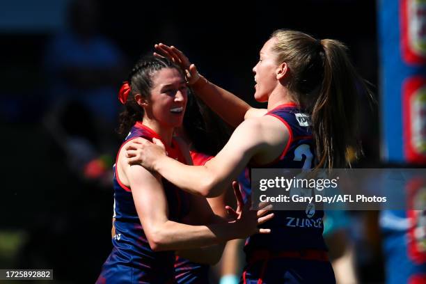 Alyssa Bannan of the Demons celebrates a goal with teammates Kate Hore and Eden Zanker during the 2023 AFLW Round 07 match between the West Coast...