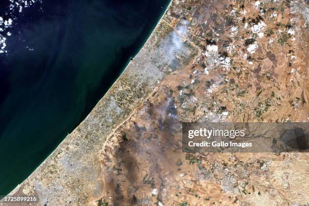 In this Satellite view of smoke plumes along the Gaza-Israel border. Imaged 7 October 2023. This image is a combination of natural with...