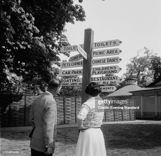 Visitors view a wooden signpost indicating the direction of various attractions and amenities at the Woburn Abbey estate, Bedfordshire, May 20th 1959.