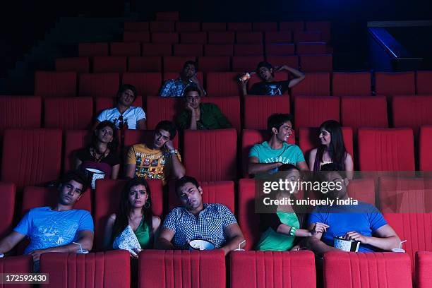 youngsters enjoying movie in a cinema hall - indian couple in theaters - fotografias e filmes do acervo