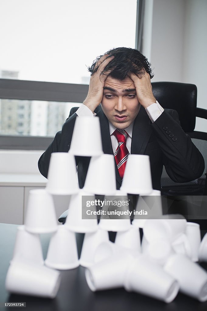 Businessman looking at a broken pyramid