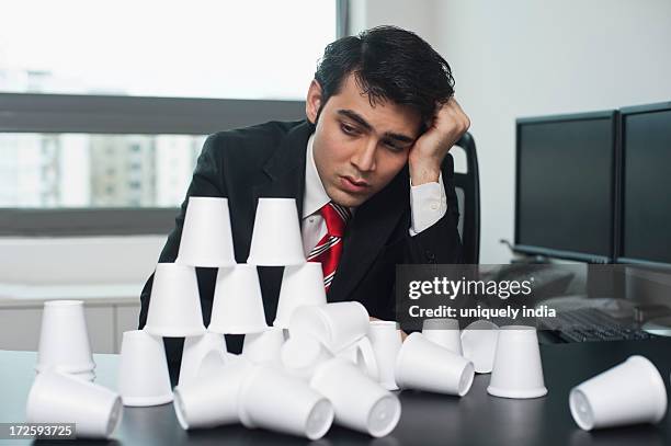 businessman looking at a broken pyramid - unbalance stockfoto's en -beelden