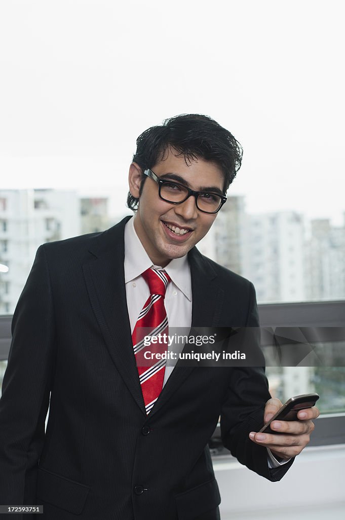 Businessman using a mobile phone and smiling