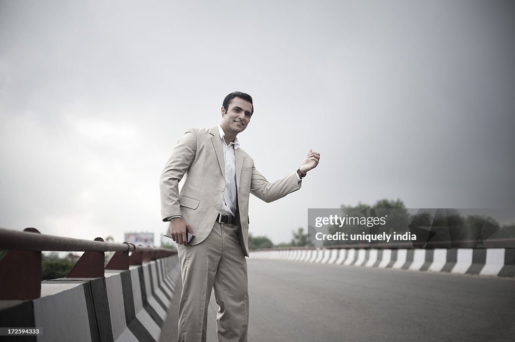 Businessman hitchhiking at the flyover