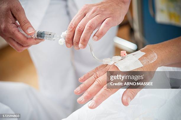 nurse preparing a patient for an iv line - iv going into an arm 個照片及圖片檔