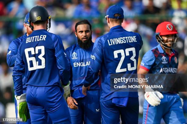 England's Adil Rashid celebrates with teammates after taking the wicket of Afghanistan's Rahmat Shah during the 2023 ICC Men's Cricket World Cup...