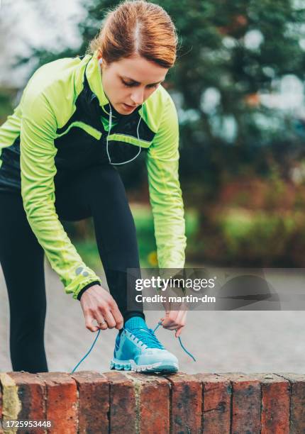 woman lacing running shoes before jogging - tying shoelace stock pictures, royalty-free photos & images