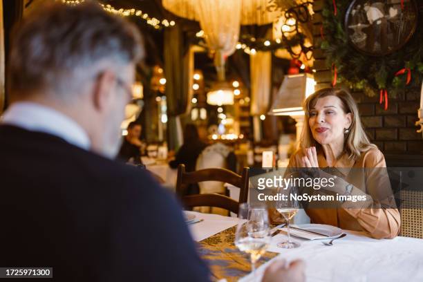 senior couple having a christmas dinner in luxury restaurant - old man woman christmas stockfoto's en -beelden