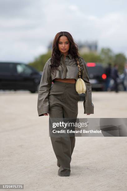 Paola Locatelli wears a green khaki leather jacket, a pastel yellow fluffy Loewe bag, matching flared suit pants, outside Loewe, during the...