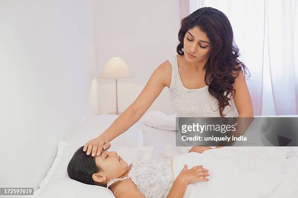 woman checking her daughter temperature - bedside table kid asleep stock pictures, royalty-free photos & images