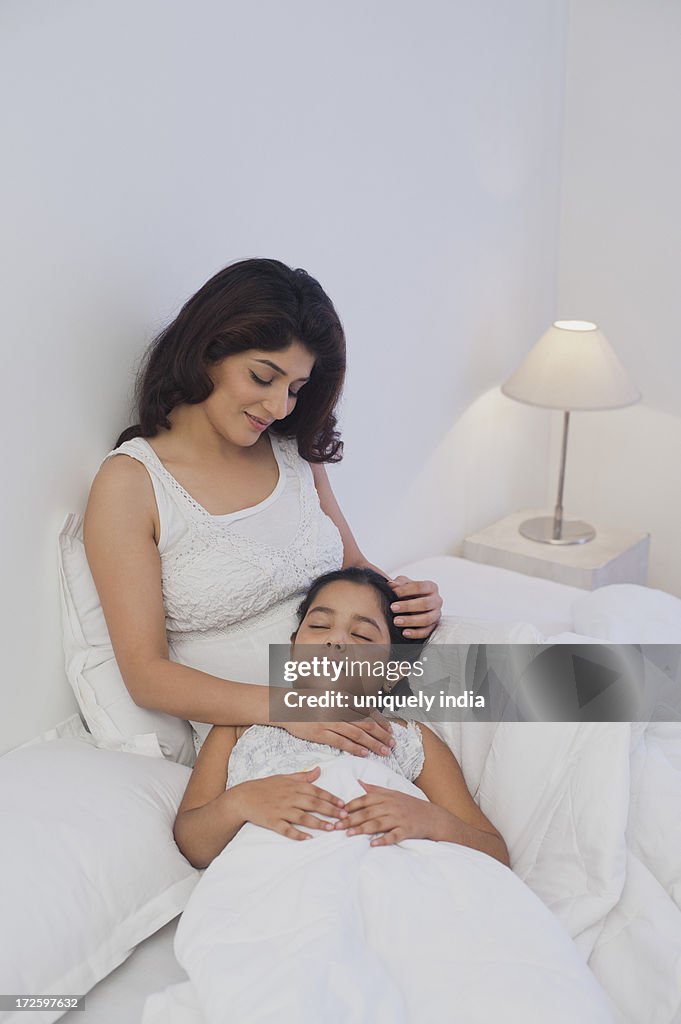 Girl resting on the lap of her mother