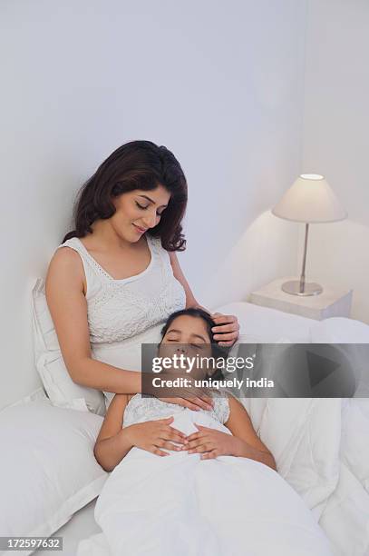 girl resting on the lap of her mother - bedside table kid asleep stock pictures, royalty-free photos & images