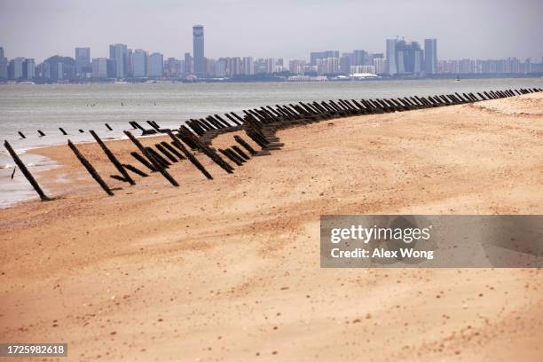 As the city of Xiamen, China, is seen in the background, wartime anti-tank obstacles sit on a beach on October 7, 2023 in Kinmen, Taiwan. Kinmen is a...