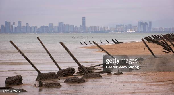 As the city of Xiamen, China, is seen in the background, wartime anti-tank obstacles sit on a beach on October 7, 2023 in Kinmen, Taiwan. Kinmen is a...