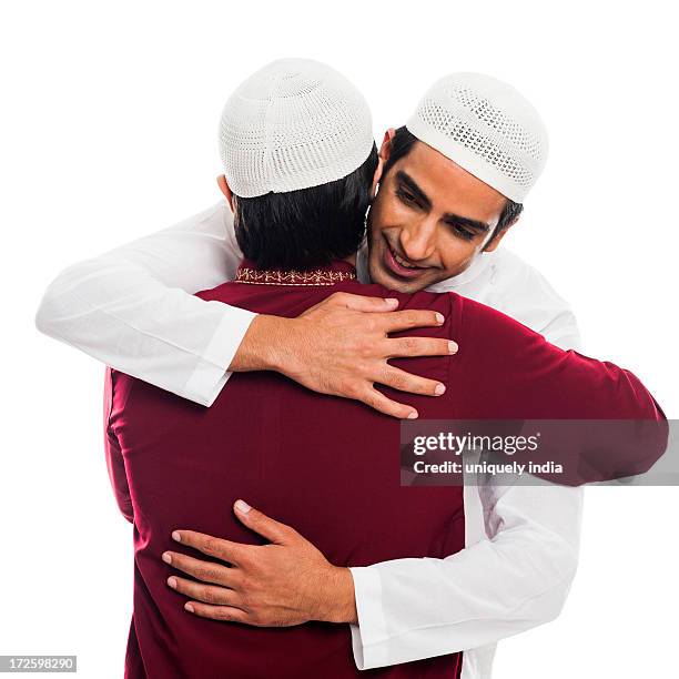 friends embracing each other during eid festival - eid al adha stock pictures, royalty-free photos & images