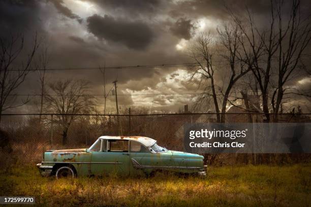 rusted car in dilapidated urban field - abandoned car fotografías e imágenes de stock
