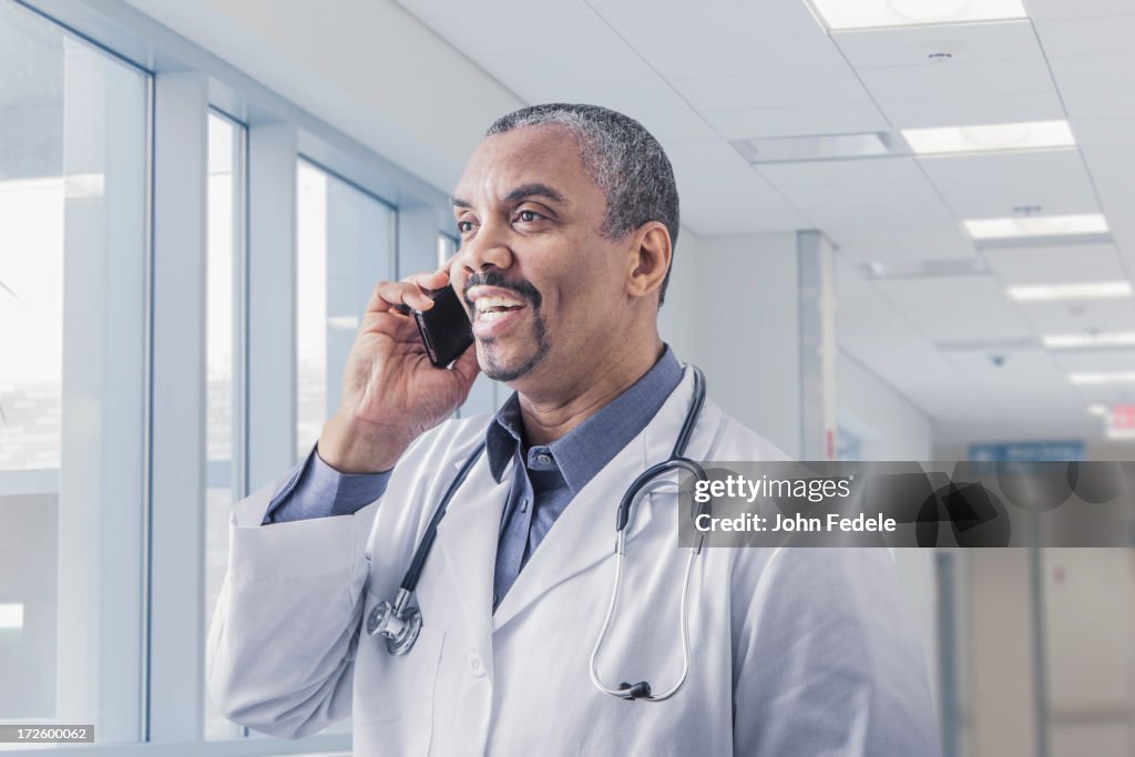 Mixed race doctor talking on cell phone in hospital