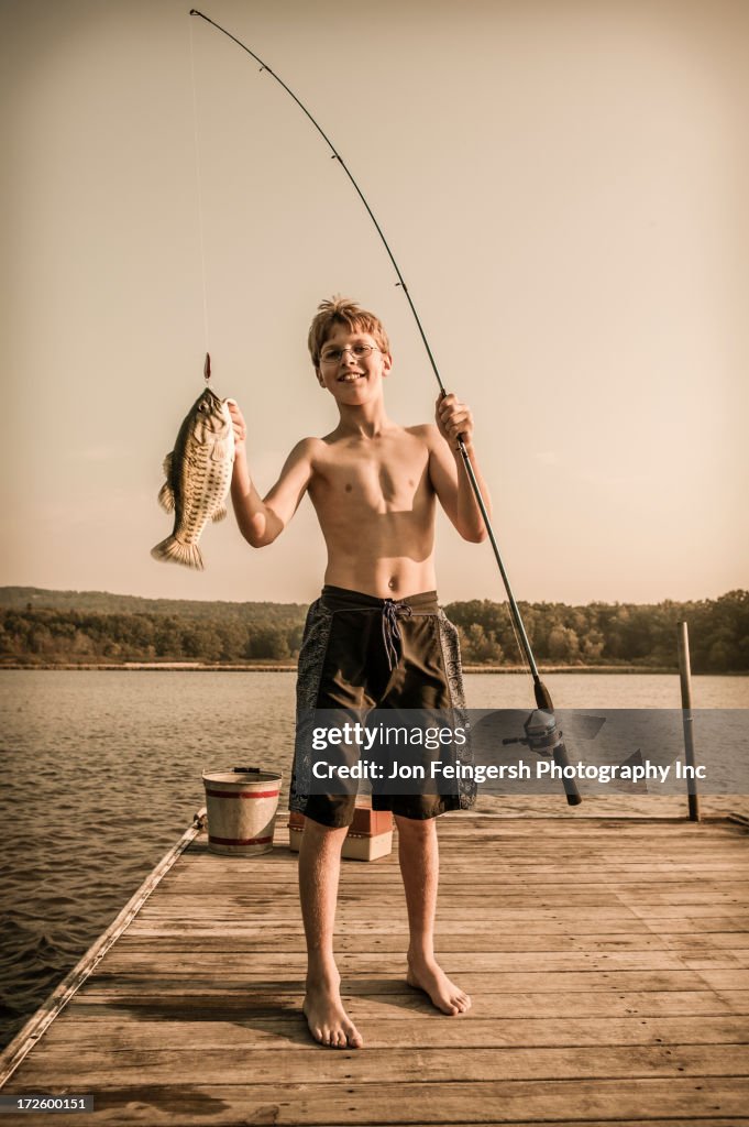 Caucasian boy holding freshly caught fish