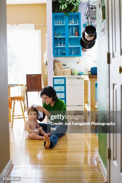 hispanic mother with toddler on kitchen floor - germantown maryland stock pictures, royalty-free photos & images