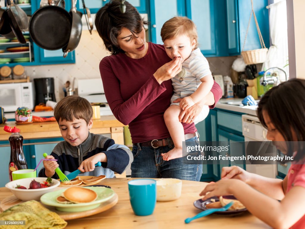 Hispanic mother and children having breakfast