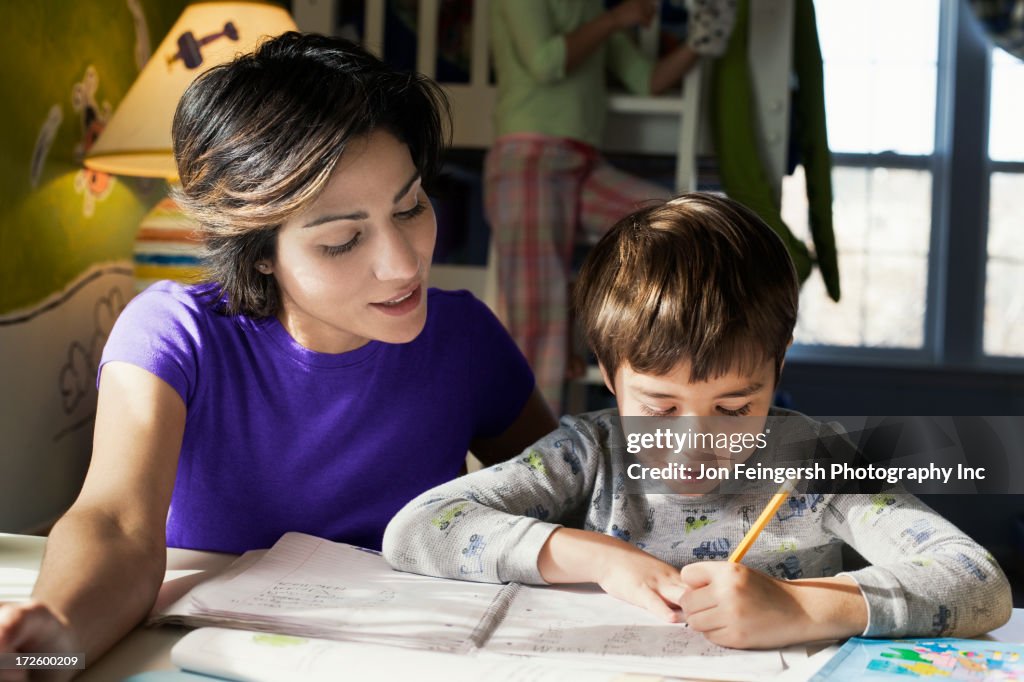 Hispanic mother helping son with homework