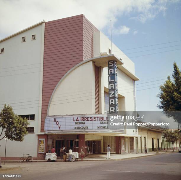 Pedestrians and an ice cream seller outside the entance to an air conditioned cinema in the city of Managua, capital of Nicaragua, central America in...