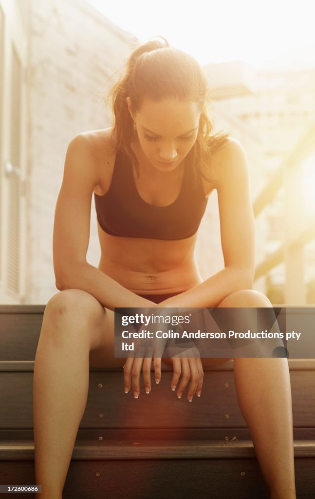 Pacific Islander athlete sitting on steps