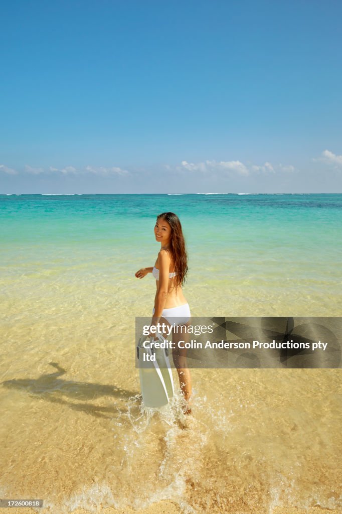 Japanese woman with snorkel fins on beach