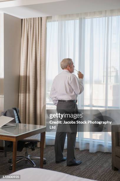 Caucasian Businessman Standing At Window, Foto de stock