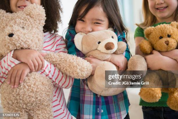 girls hugging teddy bears - child teddy bear stock pictures, royalty-free photos & images