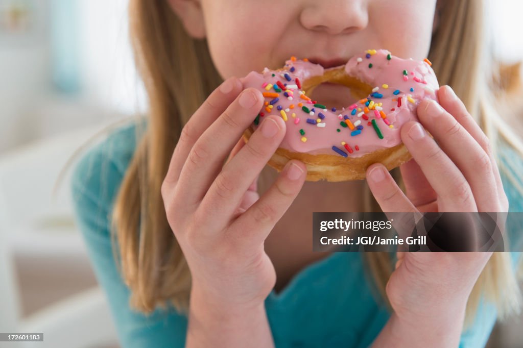 Caucasian girl eating donut