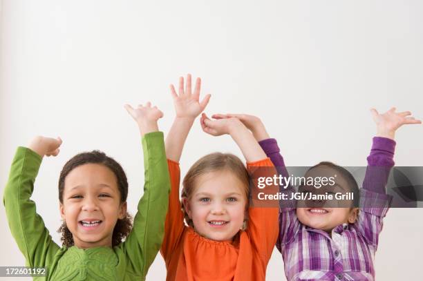 smiling girls cheering together - cheerful girl stock pictures, royalty-free photos & images